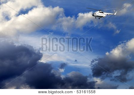 Helicopter In Blue Sky With Clouds