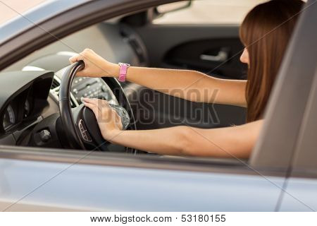 transportation and vehicle concept - woman driving a car with hand on horn button