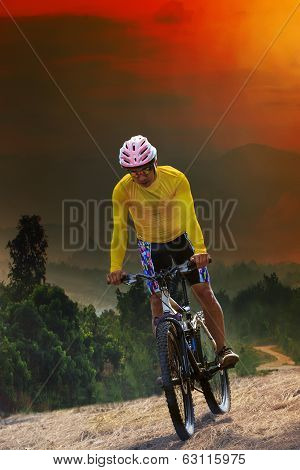 Young Man Riding Mountain Bike Bicycle Crossing Mountain Hill Jungle Track With Dusky Sky Scene Use