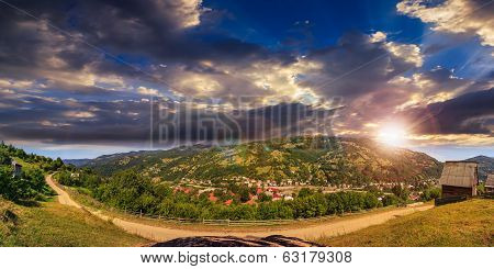 Village On Hillside Of Mountain At Sunset