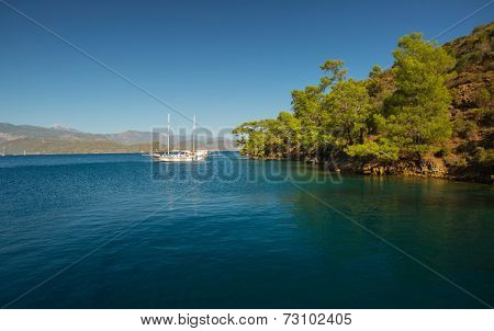 Calm bay with clear water and anchored sail boat. Skopea Limani, Turkey