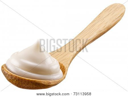 Handful of mayonnaise in wooden spoon. Isolated on a white background.