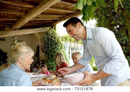 Family having summmer lunch in country house