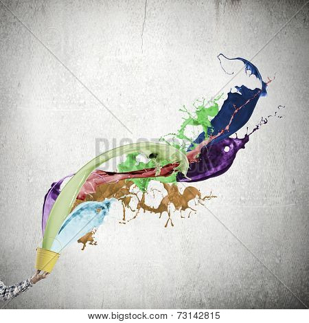 Close up of hand splashing colorful paint from bucket