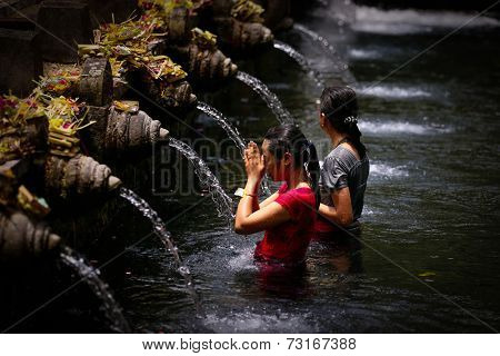 SEPTEMBER 18, 2014 - BALI, INDONESIA: Devotees bathe in the temple pool of Pura Tirta Empul in a cleansing and purification ceremony. Hinduism is the religion of the Balinese people.
