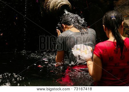 SEPTEMBER 18, 2014 - BALI, INDONESIA: Devotees bathe in the temple pool of Pura Tirta Empul in a cleansing and purification ceremony. Hinduism is the religion of the Balinese people.