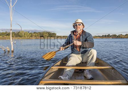 senior male enjoying morning sun on lake in a canoe, Riverbend Ponds Natural Area, Fort Collins, Colorado