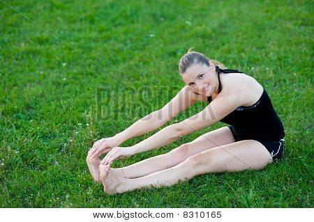 Cute adolescente s'étend ses jambes sur une grasss vert