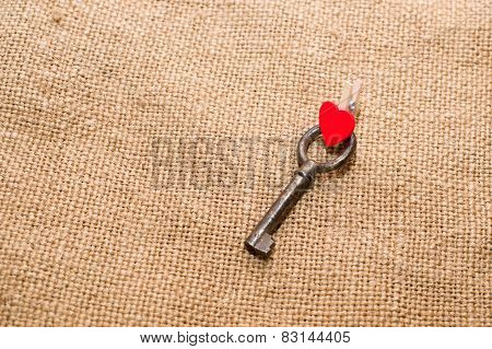 One Vintage Key And A Red Heart On Old Cloth