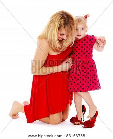 Cheerful mother helping her little daughter