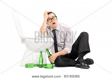 Drunk guy leaning on a toilet seat isolated on white background