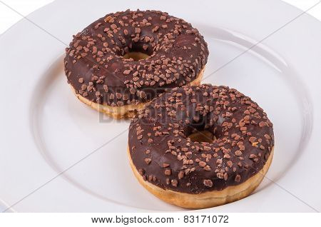 Two Donuts With Chololate Glaze On White Plate
