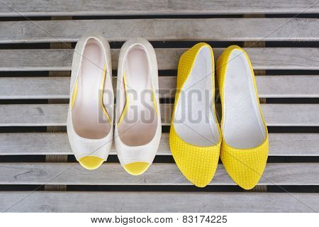 yellow ballet shoes and high heels open toe shoes on wood boards