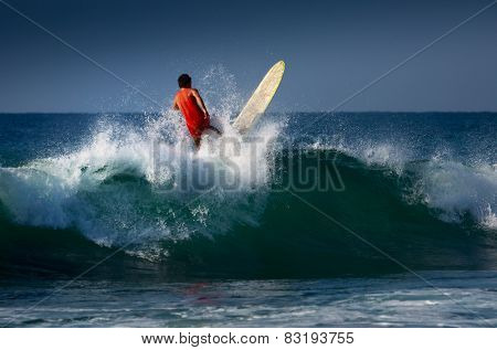 Surfer riding on the wave with long board. Midigama beach, Sri Lanka