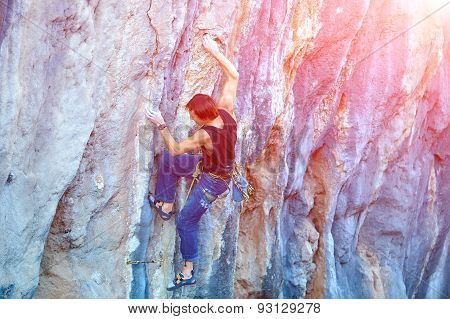 Rock climber climbing up a cliff