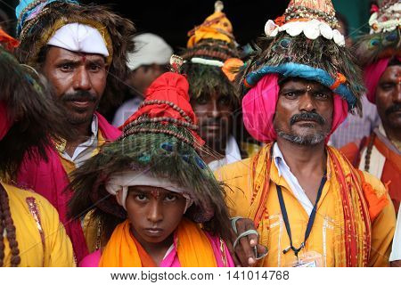 Pune, India - September 17, 2015: A groups of pilgims traditionally called as Vasudevs wearing their typical peacock feather hat.