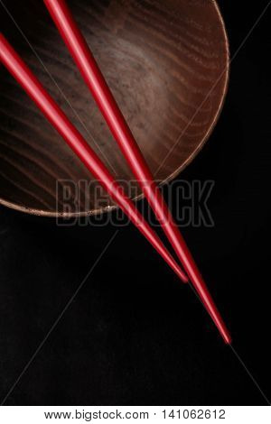 Chopsticks on top of a wooden bowl