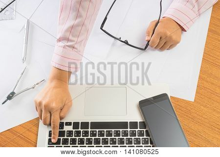 architect use laptop for architectural project on blueprint engineering concept architecture concept soft focus vintage tone