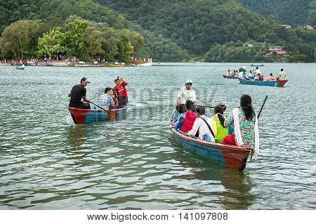 Pokhara Nepal - July 25, 2011 : Tourists enjoy boat ride in vast Phewa Lake, natural colors. Phewa lake is a tourist spot located at an altitude of 742 m