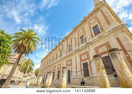 Seville, Andalusia, Spain - April 18, 2016: the facade of the Casa Lonja with the Archive of the Indies, Plaza del Triunfo in Seville's old town.