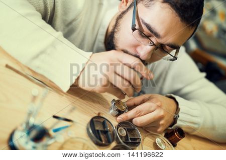 Close up portrait of a watchmaker at work.A watchmaker or repair man in actionviewing very closely.