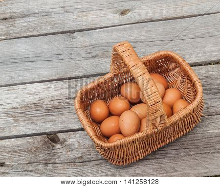 Brown eggs in the basket on a wooden table