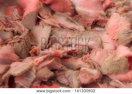 sliced roasted beef on background - meat cut into thin slices
