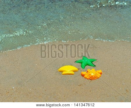 Three children's plastic forms for playing with sand green starfish shell yellow orange crab sand Beach sea