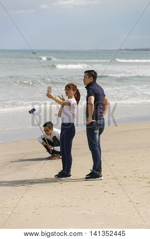 Young People Using Selfie Stick At China Beach Danang