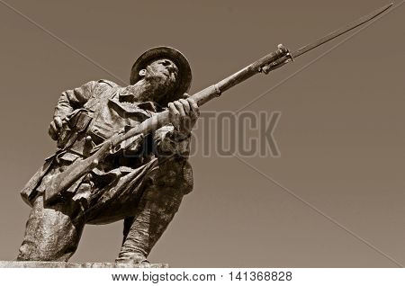 A statue of a British WW1 soldier, wearing a Brody helmet and carrying an SMLE (Lee Enfield) .303 rifle with pattern 1907 bayonet fixed.