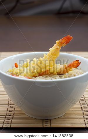 Tom Yum Soup with noodles, visible fried prawns, side view, vertical