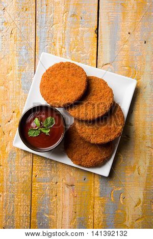 Indian chat item aloo or aalu tikki or tikiya or fried potato cake also known as ragda patties served with tomato ketchup, selective focus