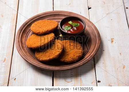 Indian chat item aloo or aalu tikki or tikiya or fried potato cake also known as ragda patties served with tomato ketchup, selective focus
