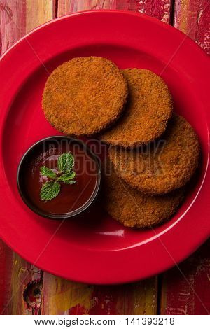 Indian chat item aloo or aalu tikki or tikiya or fried potato cake also known as ragda patties served with tomato ketchup, selective focus