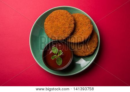 Indian chat item aloo or aalu tikki or tikiya or fried potato cake also known as ragda patties served with tomato ketchup, selective focus