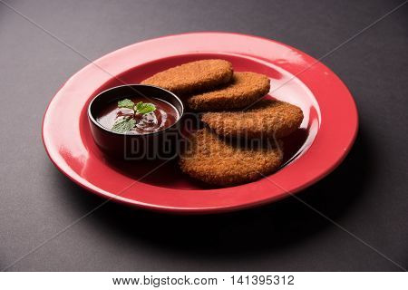Indian chat item aloo or aalu tikki or tikiya or fried potato cake also known as ragda patties served with tomato ketchup, selective focus