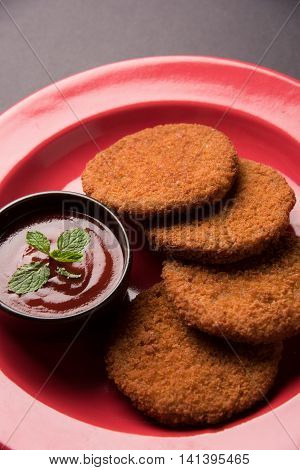 Indian chat item aloo or aalu tikki or tikiya or fried potato cake also known as ragda patties served with tomato ketchup, selective focus