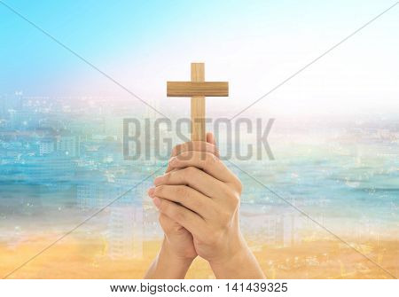 Human hands holding a cross holy and prayed for blessings from God. Amour Worship God concept.