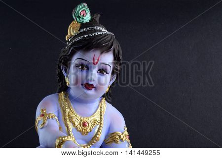 Hindu God Krishna. Statue of God Krishna on dark background