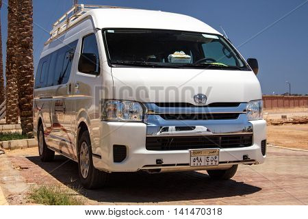 EGYPT, SHARM EL SHEIKH - JULY 20, 2015: Sharm el-Sheikh is holiday resort and significant centre for tourism in Egypt. White commercial passenger mini bus waiting for tourists