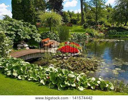 Beautiful classical design landscaped lush green blooming garden fish pond with water lily