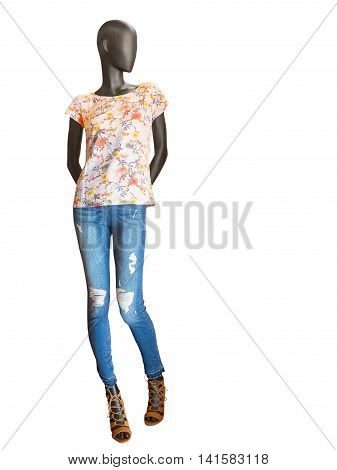 Female mannequin dressed in jeans and floral t-shirt isolated on white background. No brand names or copyright objects.