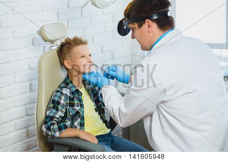 Ent doctor or Otolaryngologist examining a kid nose.