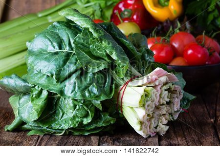 Bunch of mangold. Fresh mangold and vegetables on wooden rustic background