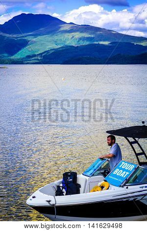 Man on the tour motor boat at the Loch Lomond lake in Scotland, 21 July 2016