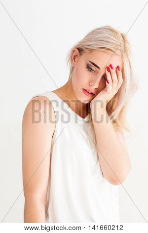 Attractive blonde woman with headache. Young female put palm on her head. Migraine, tiredness, frustration concept