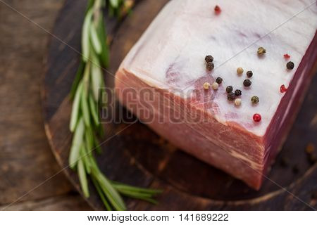 Whole pepper on raw meat. Green herb on a plate. Spices for beef. How to prepare delicious steak.