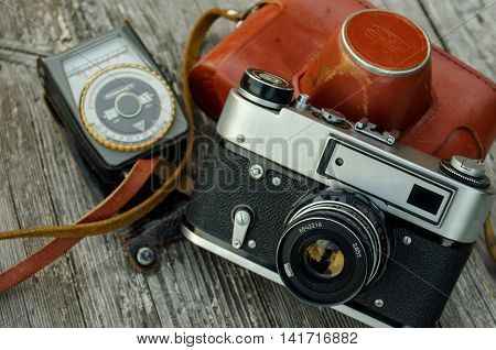 old camera in a leather case and a light meter