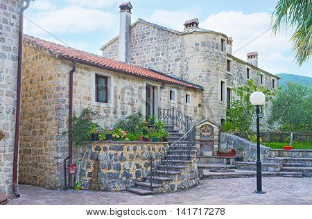 The living buildings of Podmaine Monastery with the small drinking fountaine decorated with mosaic icon of Mother of God Budva Montenegro.