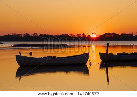 Fishing boats in the sunset in a small port